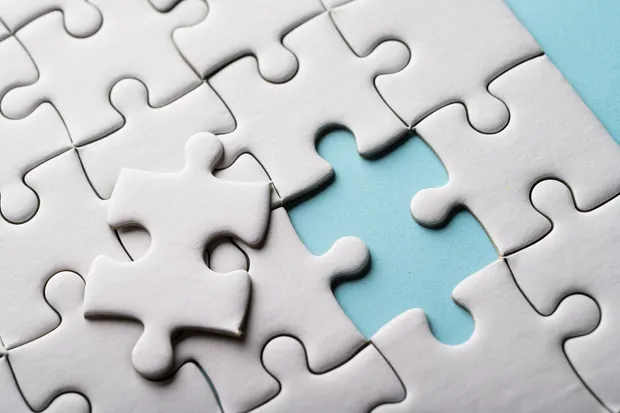 A jigsaw puzzle with one piece still missing